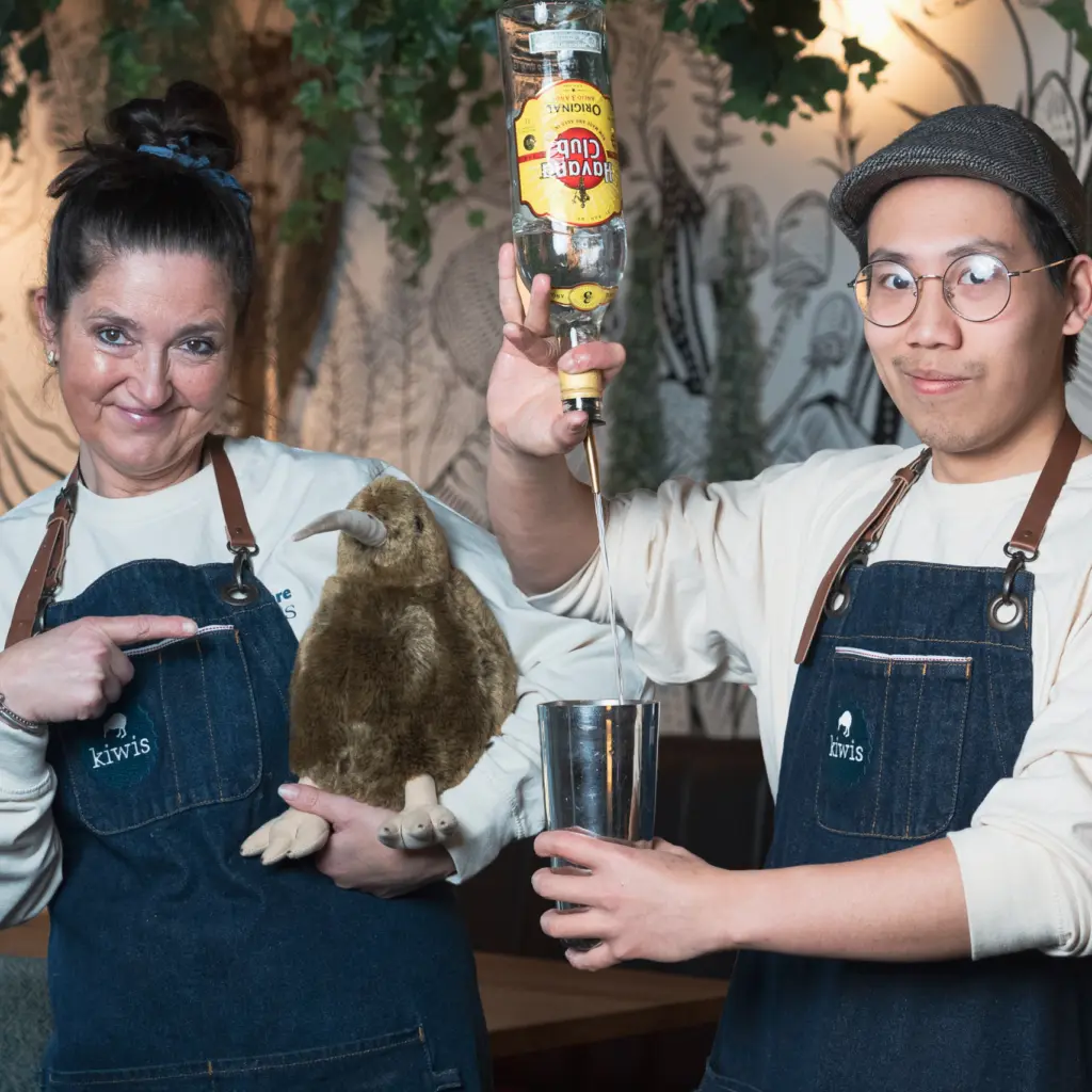 Zwei aus dem kiwis-Team mit Kiwi-Plüschvogel und Flasche