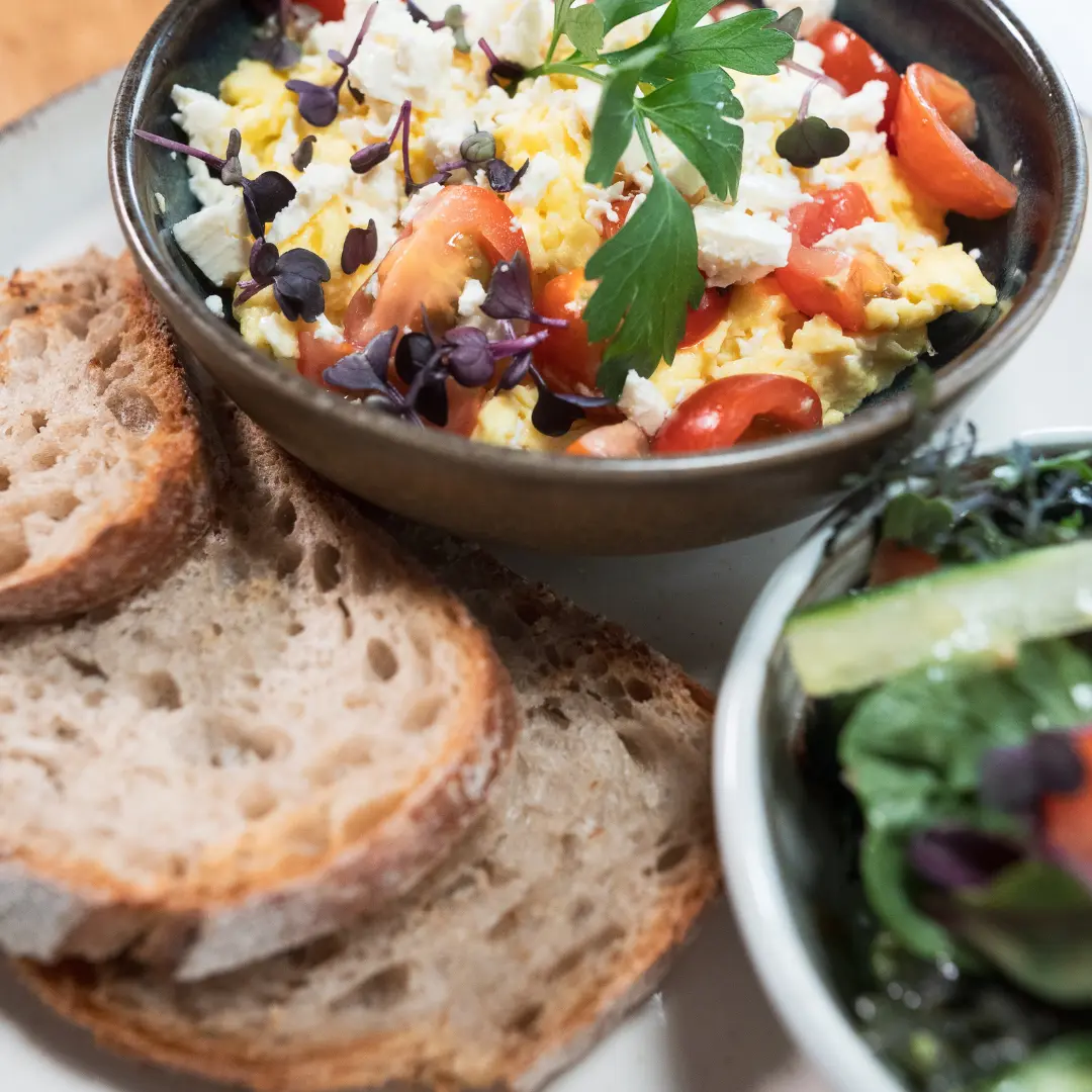Rührei mit Tomaten und Kräutern, dazu Brot und Salat