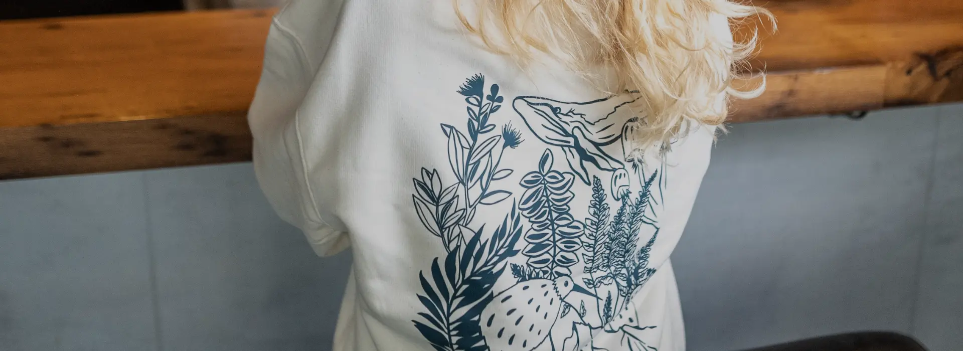Rückseite des weißen kiwis-Pullovers mit Pflanzenmotiv