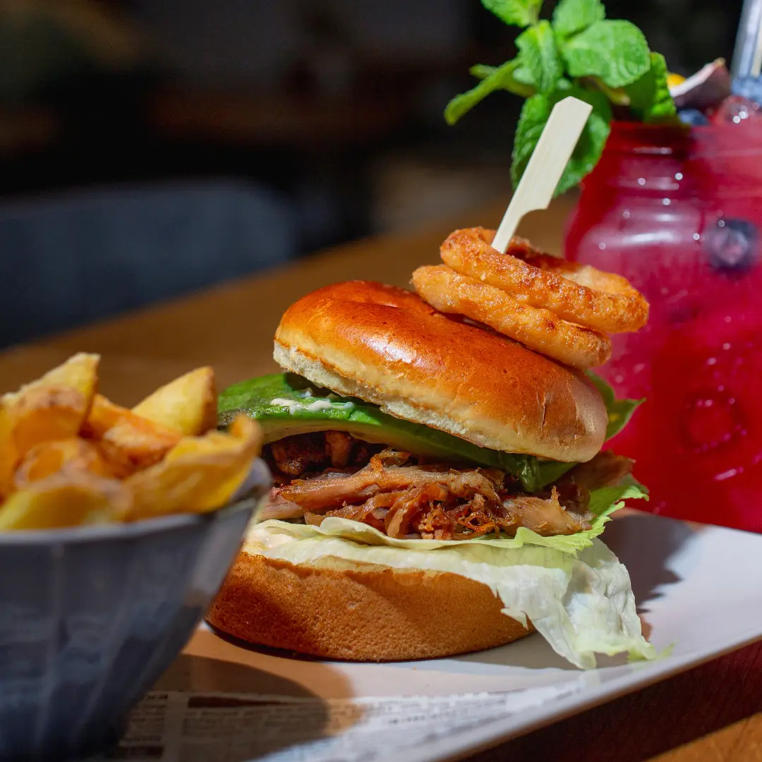 Burger „Turkey Avo Bliss“ mit Zwiebelringen und Pommes