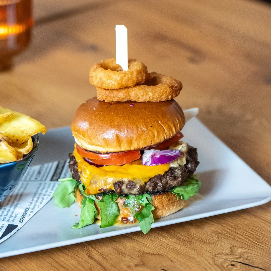 Burger „kiwis Classic“ mit Käse, Zwiebelringen und Pommes